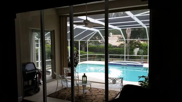 Clean sliding glass doors looking out to a screened pool enclosure